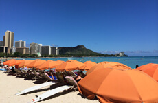 ワイキキビーチとオレンジのパラソル